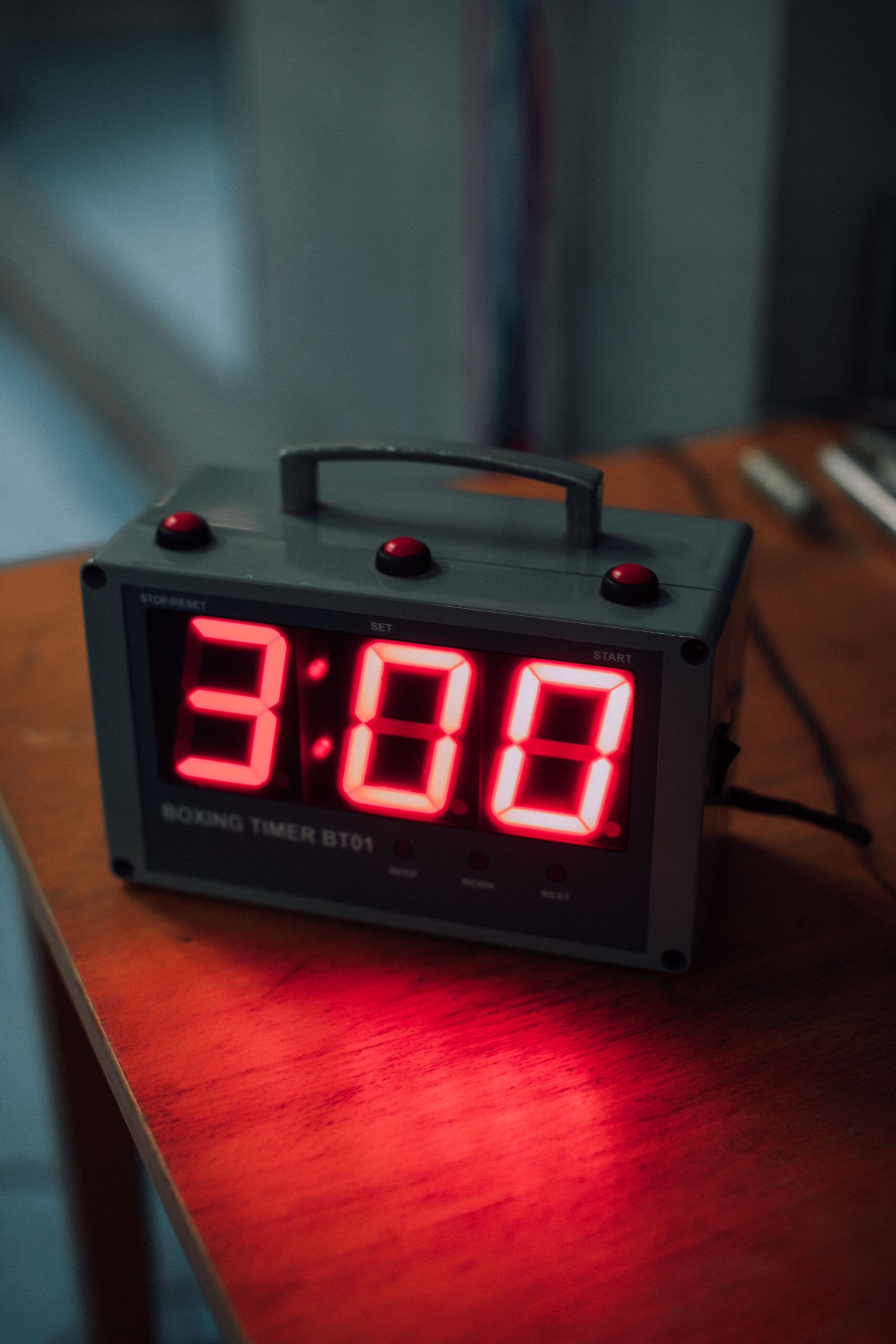 Close-up of an electronic boxing timer displaying three minutes with a red LED screen.